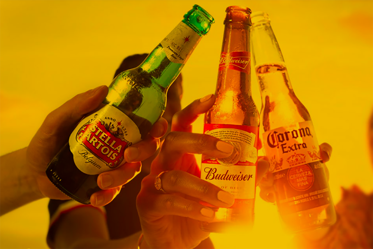 Three people toasting with bottles of beer