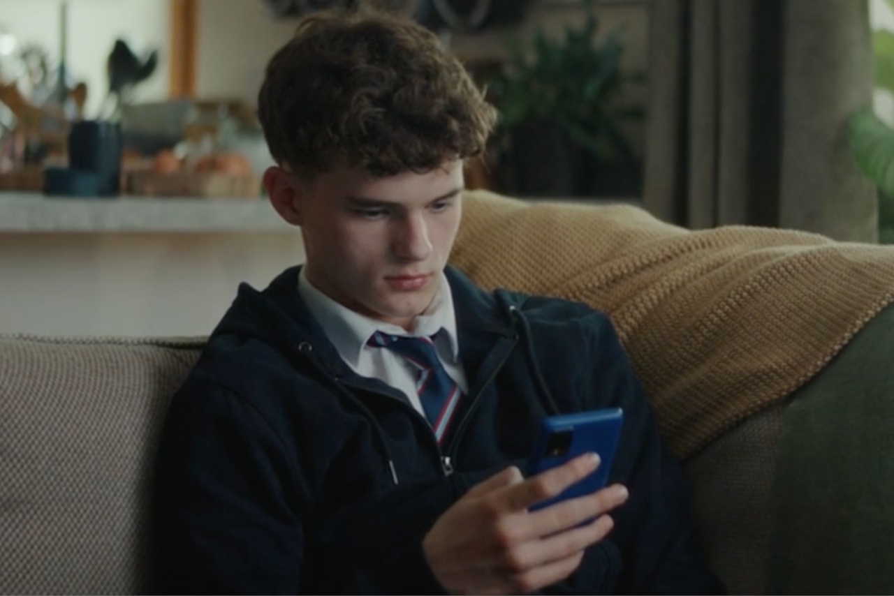 Boy looking at smart phone in the sofa 