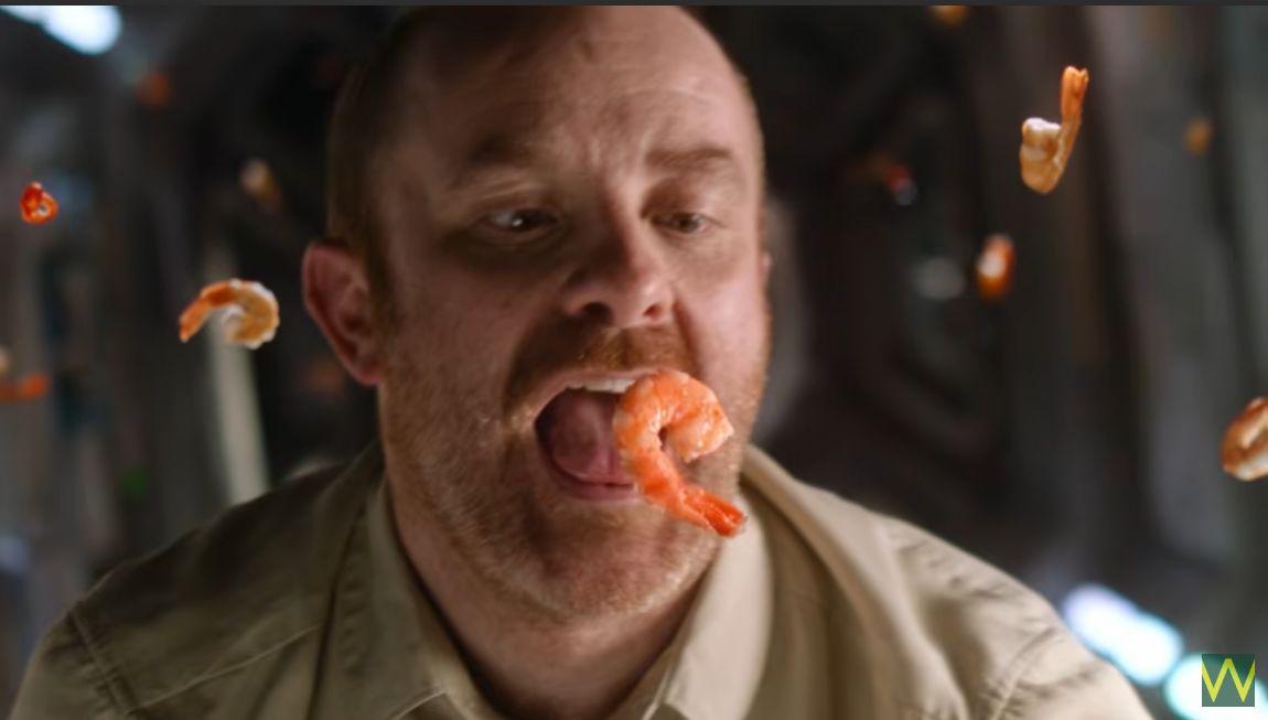 Man eating floating prawn in space